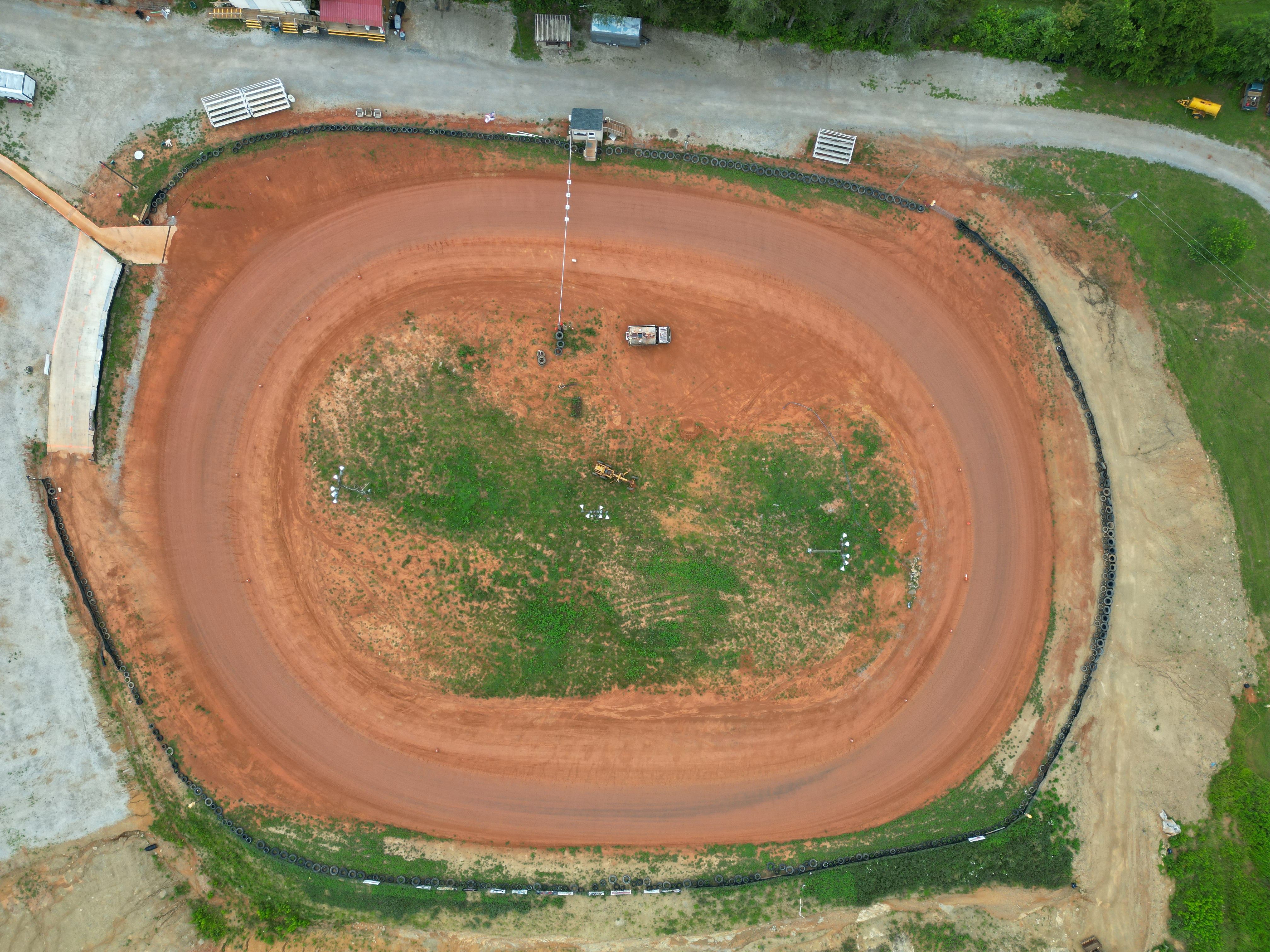Late model cars running the middle groove as a Florida dirt track goes slick