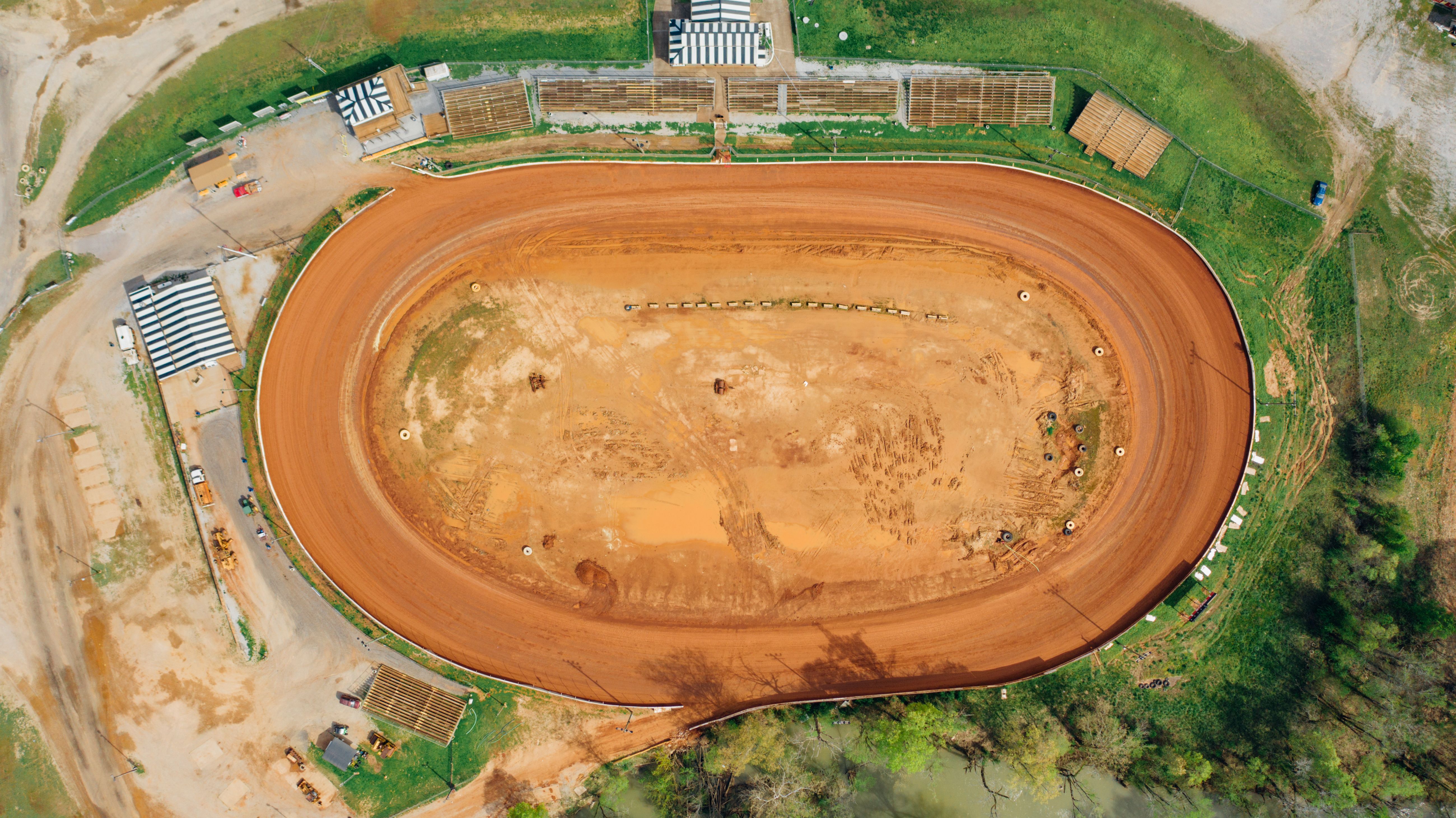 Sprint car working the cushion on a dry slick clay oval at night